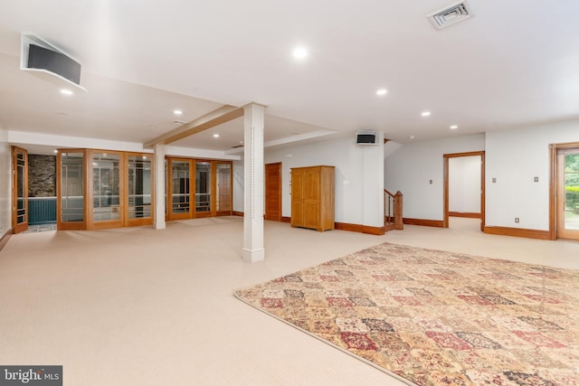 spare room with decorative columns and light colored carpet