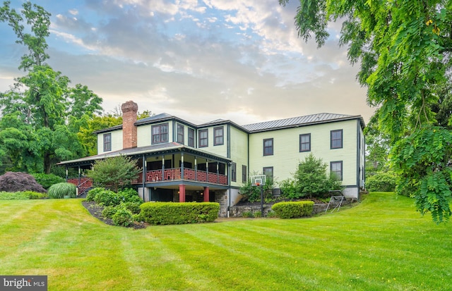 rear view of property featuring a lawn