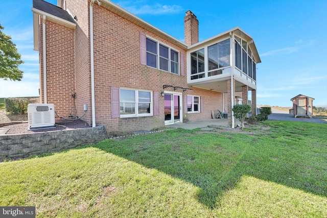 rear view of property featuring a patio, central AC unit, and a lawn