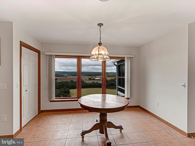 unfurnished dining area featuring a notable chandelier and light tile flooring