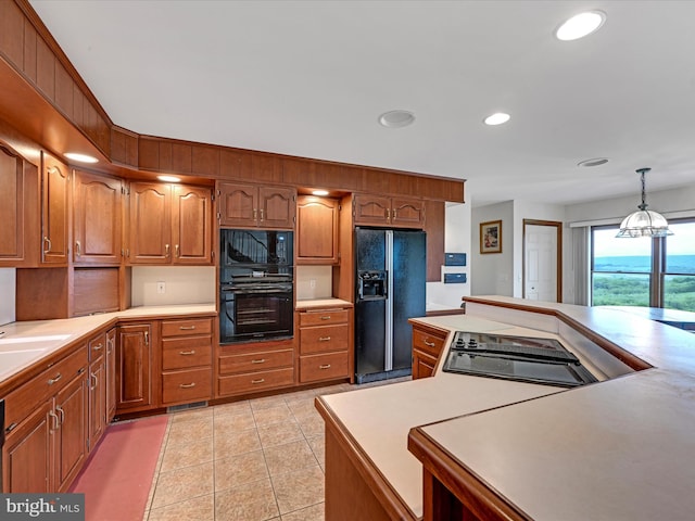 kitchen featuring black appliances, light tile floors, and pendant lighting