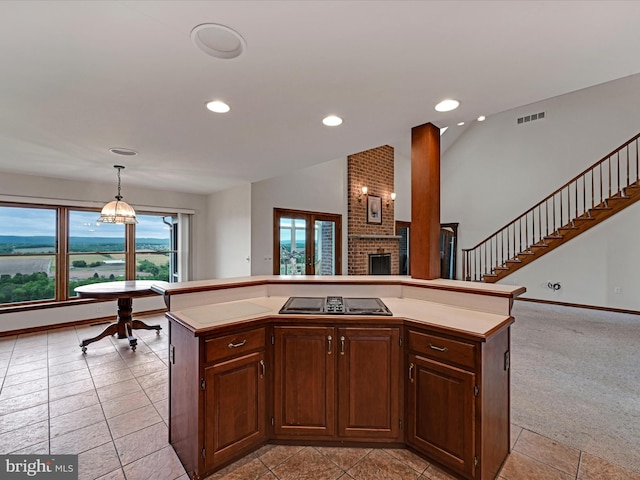 kitchen with hanging light fixtures, a kitchen island, light colored carpet, and brick wall