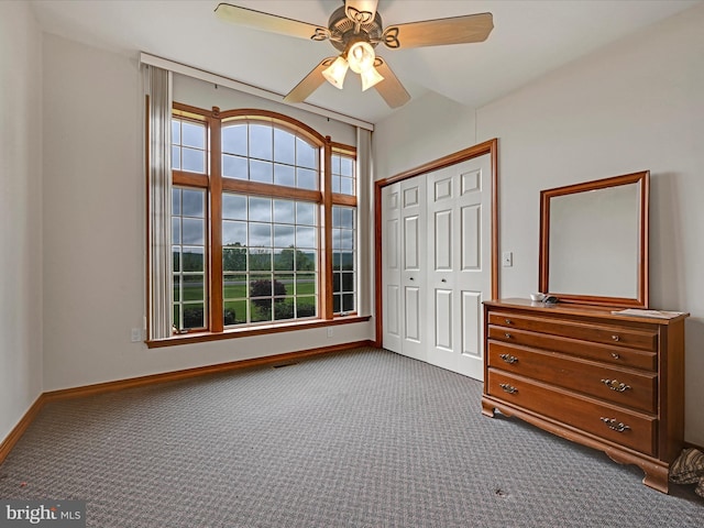 unfurnished bedroom featuring ceiling fan, multiple windows, a closet, and carpet flooring