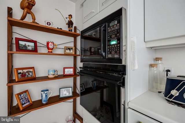 202 W Rittenhouse Sq Unit 1105, Philadelphia, PA 19103 - kitchen view of black appliances, open shelves, white cabinets, and light countertops