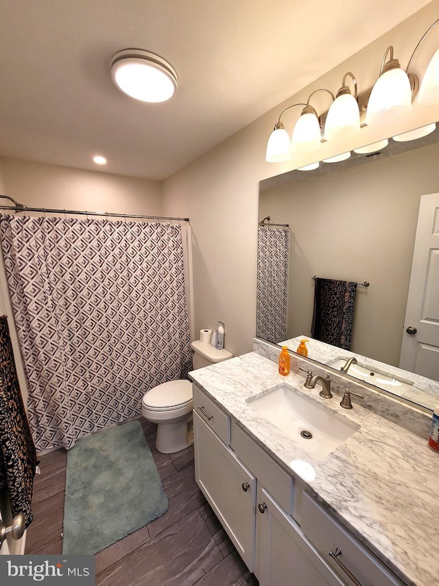 bathroom with vanity, wood-type flooring, and toilet