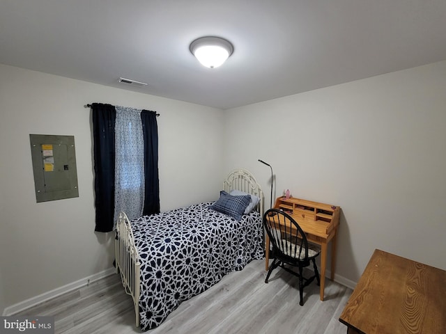 bedroom featuring light hardwood / wood-style floors and electric panel