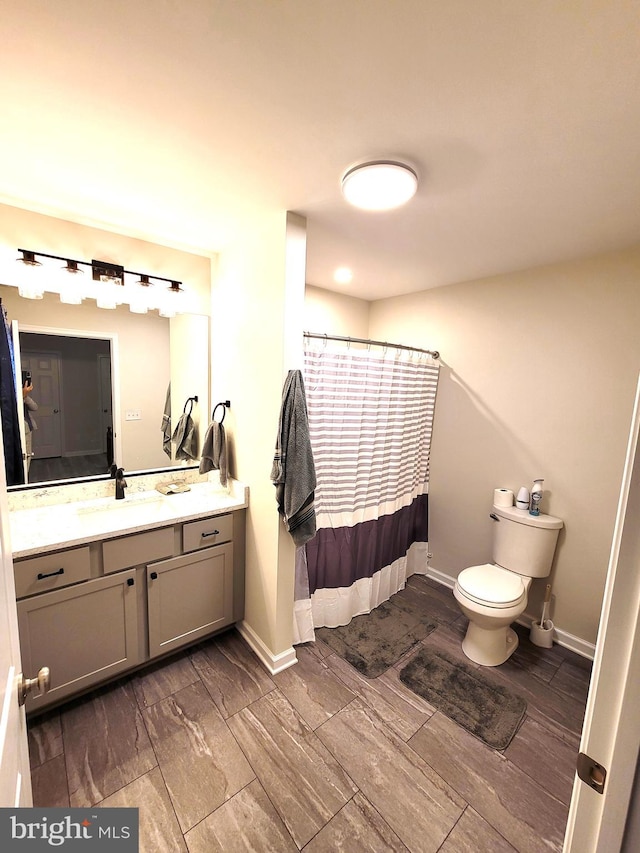 bathroom featuring vanity, wood-type flooring, toilet, and walk in shower