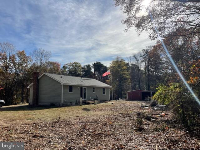 back of property featuring a storage shed