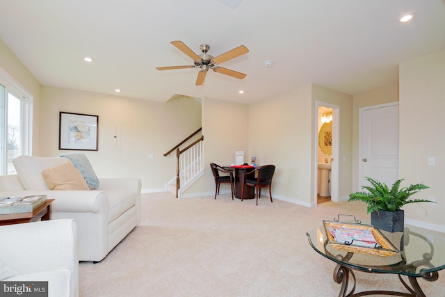 living area featuring light colored carpet and ceiling fan