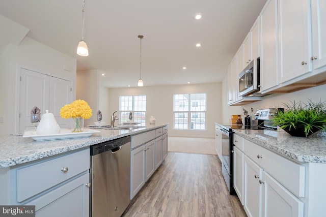 kitchen with white cabinetry, light hardwood / wood-style floors, light stone counters, and stainless steel appliances