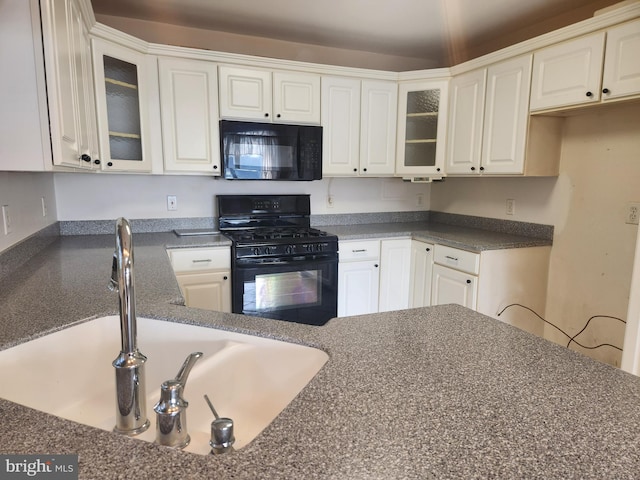 kitchen featuring black appliances, white cabinets, and sink