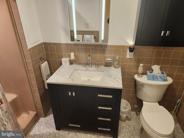 bathroom featuring walk in shower, tile patterned flooring, toilet, vanity, and tile walls