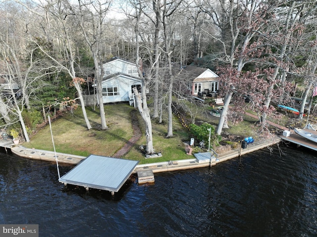 view of dock featuring a lawn and a water view