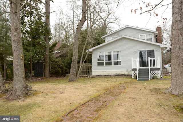 rear view of property with a lawn