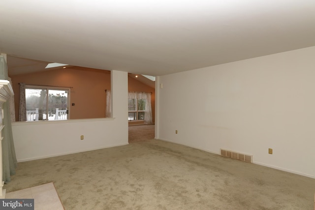 unfurnished living room featuring a fireplace, light colored carpet, and vaulted ceiling