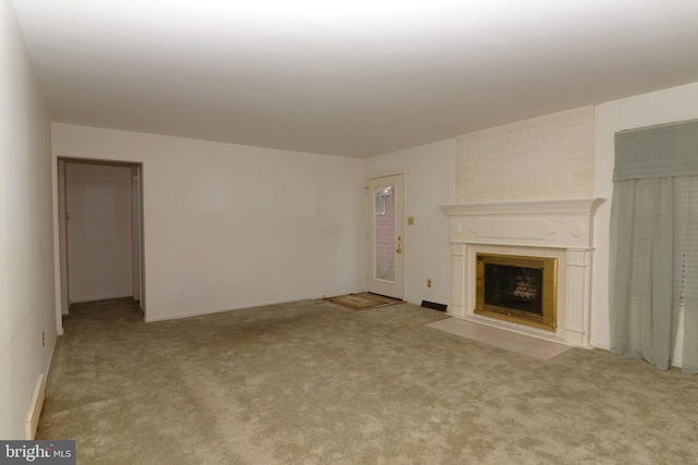 unfurnished living room with light carpet and a large fireplace