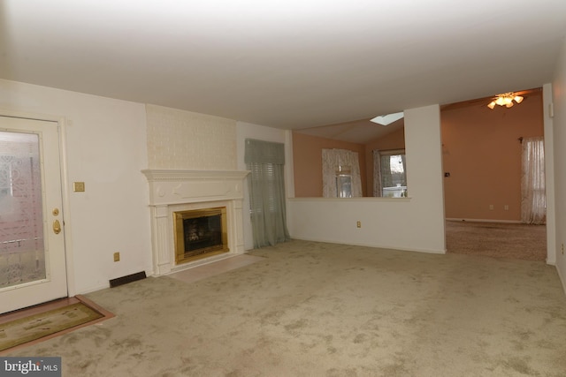 unfurnished living room with light carpet, a large fireplace, and vaulted ceiling