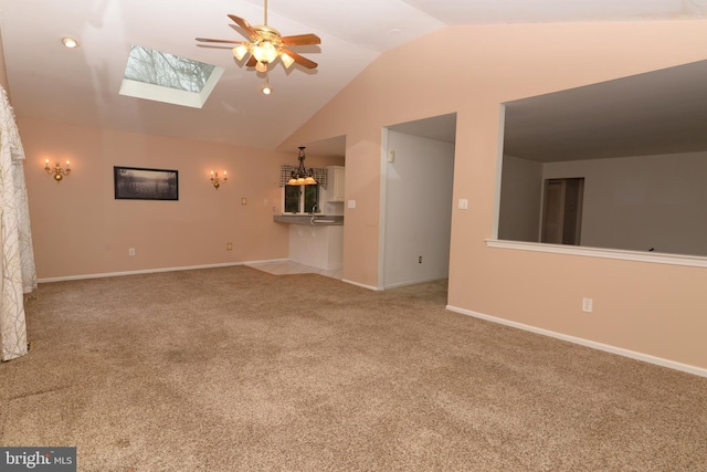 unfurnished living room with light carpet, ceiling fan, and vaulted ceiling with skylight