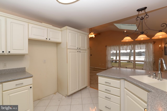 kitchen featuring ceiling fan, sink, hanging light fixtures, lofted ceiling, and light tile patterned floors