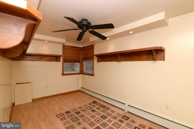 spare room featuring baseboard heating, ceiling fan, and light wood-type flooring