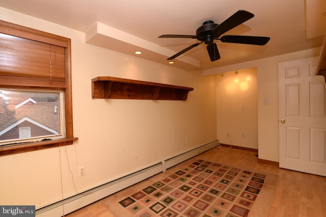 unfurnished room featuring ceiling fan, light hardwood / wood-style floors, and baseboard heating