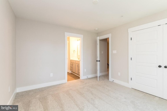 unfurnished bedroom featuring connected bathroom and light colored carpet