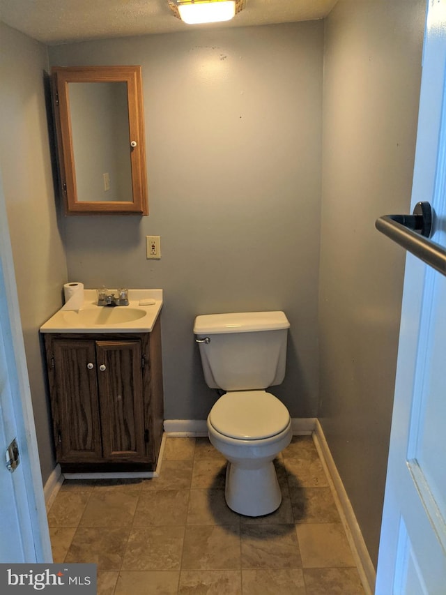 bathroom with vanity, toilet, and tile floors