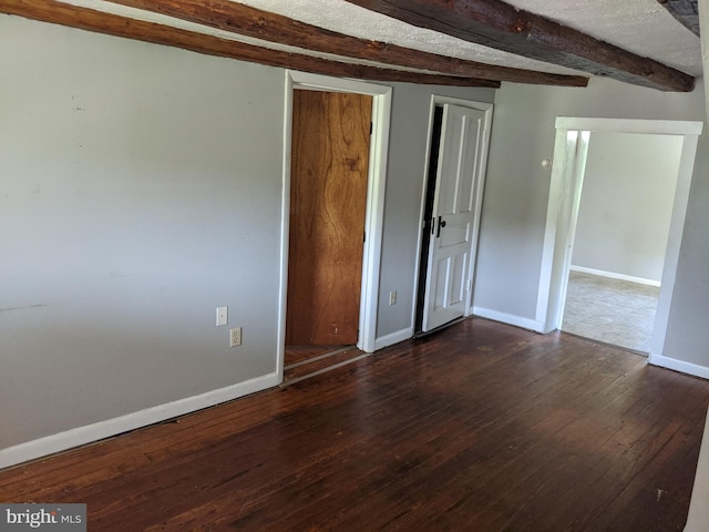 unfurnished bedroom featuring beam ceiling and dark wood-type flooring