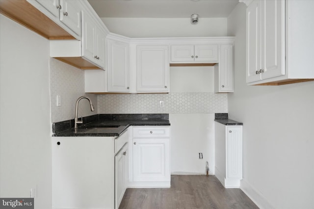 kitchen with backsplash, sink, white cabinetry, and light wood-type flooring