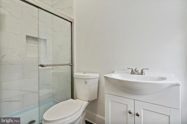 bathroom with a shower with door, toilet, and vanity