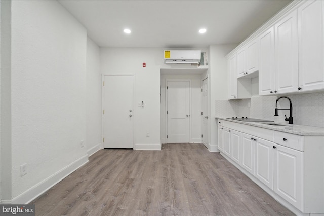 kitchen featuring tasteful backsplash, light hardwood / wood-style floors, white cabinets, and sink