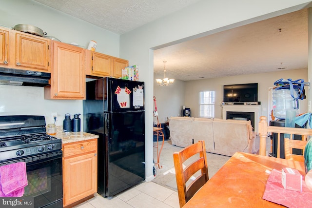 kitchen with a chandelier, a textured ceiling, light tile floors, and black appliances