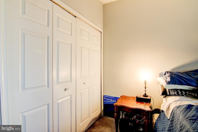 bedroom with dark carpet and a closet