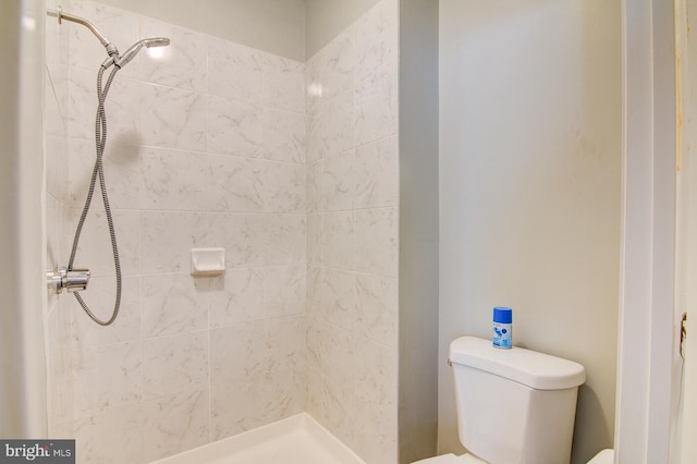 bathroom with toilet and a tile shower