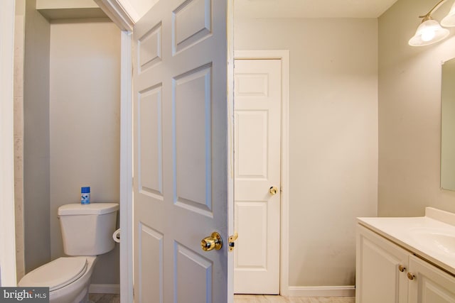 bathroom with toilet, tile floors, and vanity