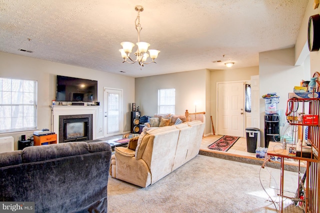 carpeted living room featuring a notable chandelier and a textured ceiling