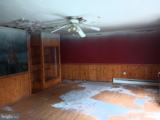 empty room with a baseboard heating unit and ceiling fan