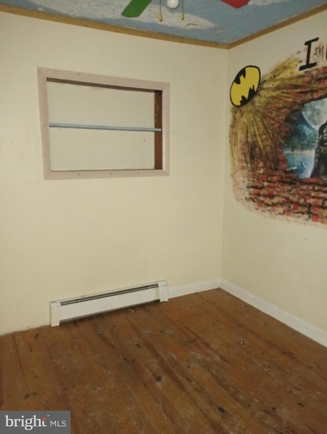 spare room with baseboard heating and wood-type flooring