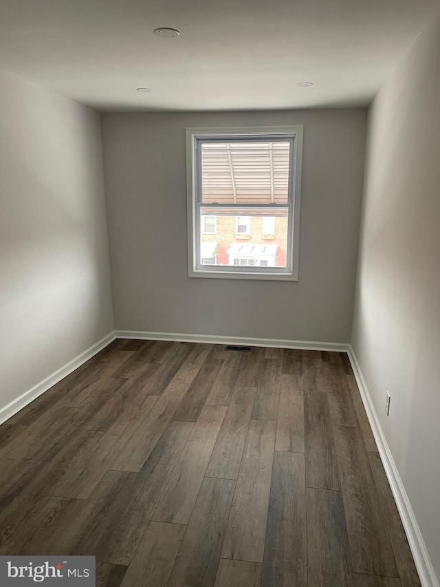 unfurnished room with dark hardwood / wood-style flooring