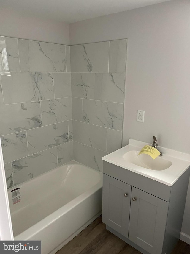 bathroom featuring hardwood / wood-style floors, vanity, and bathtub / shower combination