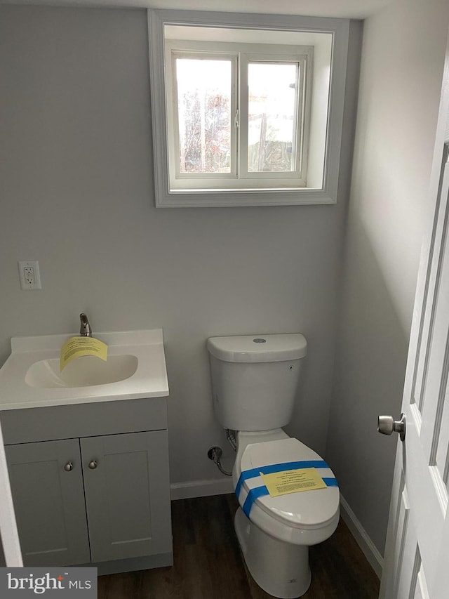 bathroom featuring wood-type flooring, vanity, and toilet