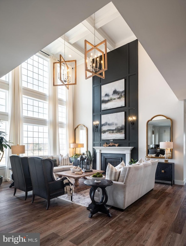 living room featuring dark wood finished floors, a fireplace, beamed ceiling, and a high ceiling