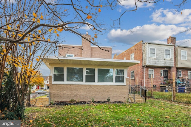 back of house featuring a lawn