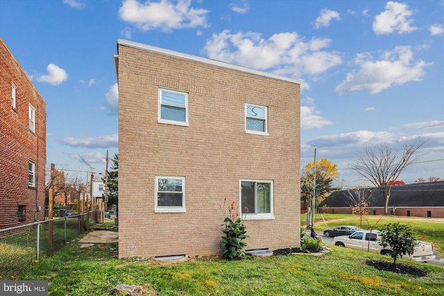 rear view of property featuring a lawn