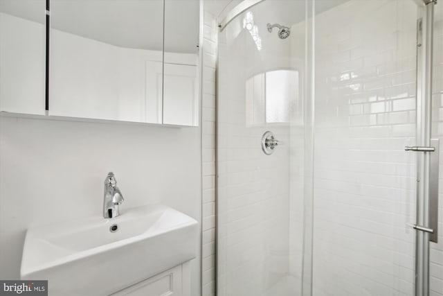 bathroom featuring an enclosed shower and sink