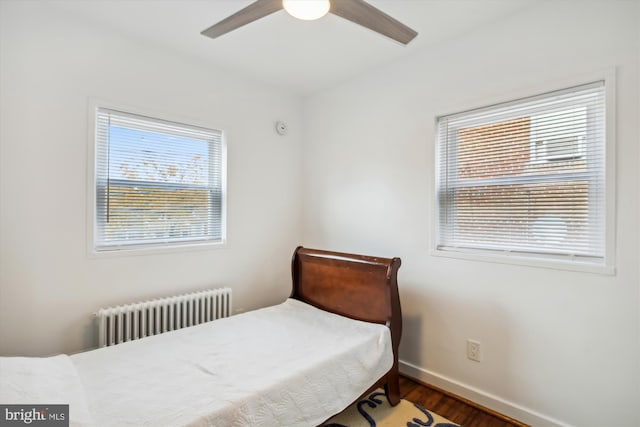 bedroom featuring ceiling fan, dark wood-type flooring, and radiator