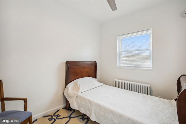 carpeted bedroom with ceiling fan and radiator