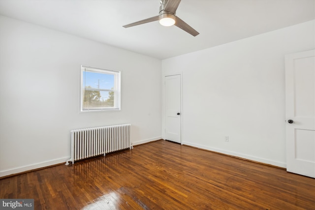 empty room with ceiling fan, dark hardwood / wood-style floors, and radiator heating unit