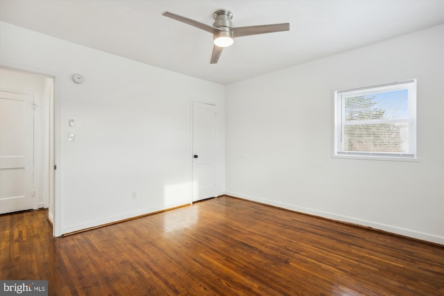 empty room with ceiling fan and dark wood-type flooring