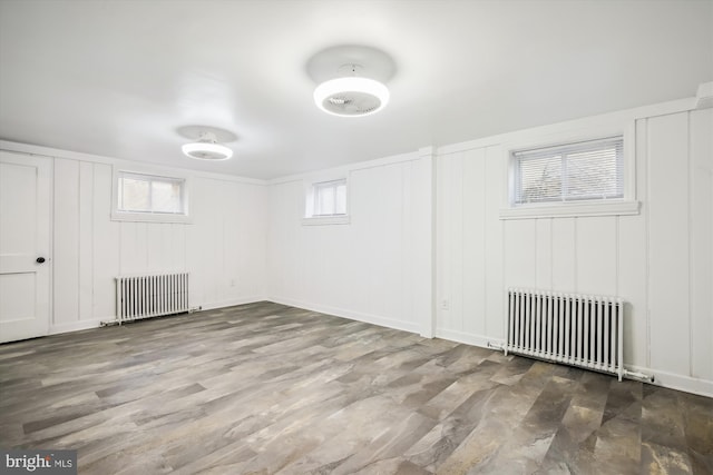 basement with wood-type flooring and radiator